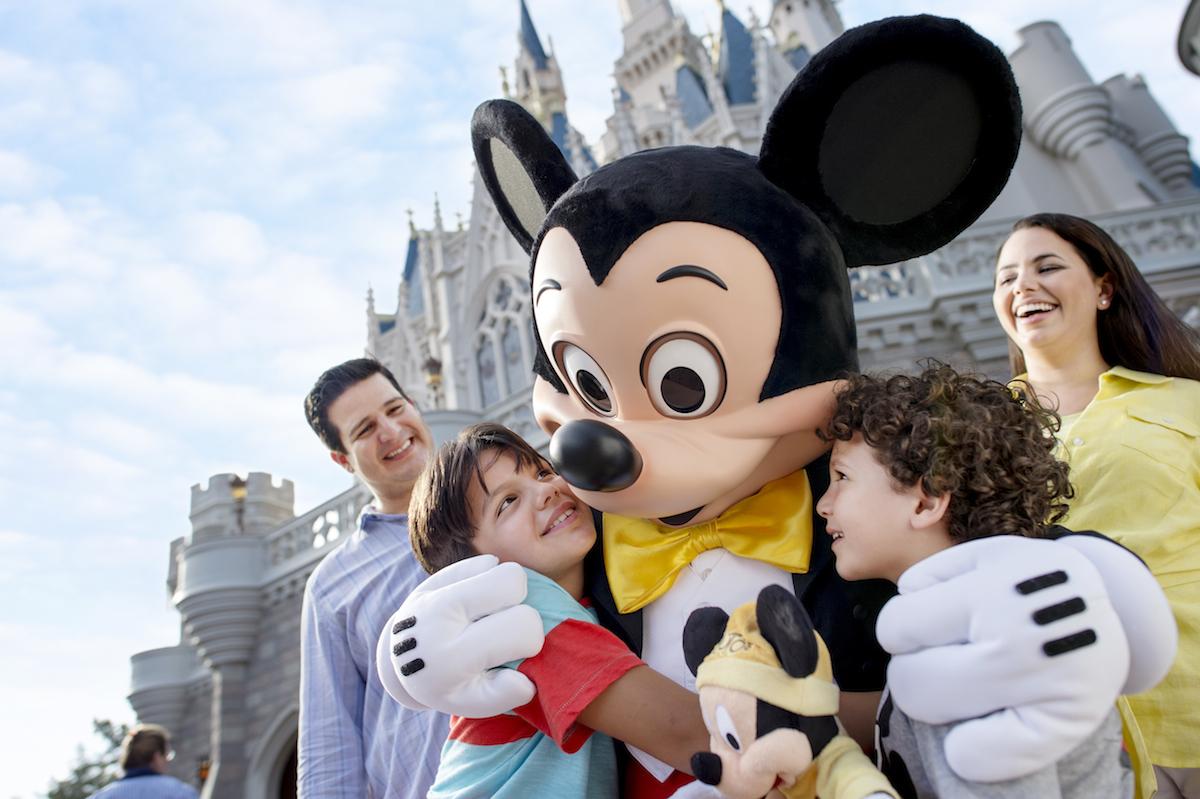 Niños abrazando a Mickey Mouse